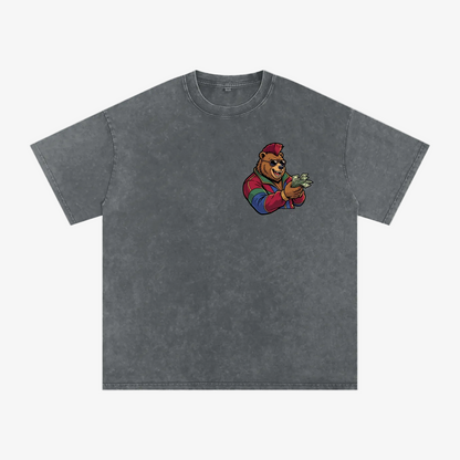 A dark gray acid-wash t-shirt featuring a cartoon graphic of a bear wearing a red cap and colorful sleeves, holding cash, on the left chest. The t-shirt is displayed flat against a solid white background.