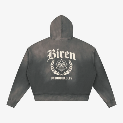 A dark gray acid-wash cropped hoodie shown from the back, featuring a distressed cream graphic with the word 'Biren', an all-seeing eye inside a triangle, laurel branches, and the word 'UNTOUCHABLES'.