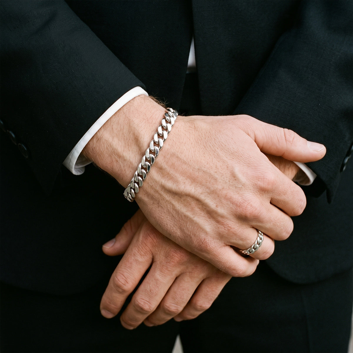8mm silver curb chain bracelet worn with a black suit and white shirt cuff