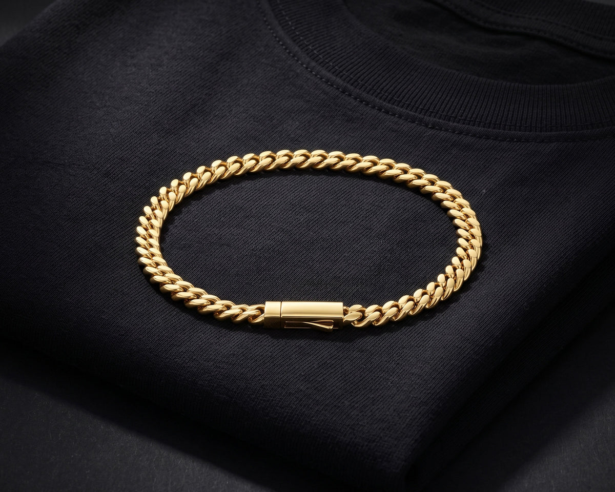 Gold 5mm curb chain bracelet resting on a folded black t-shirt