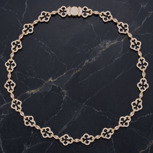 Gold iced cross link chain necklace on black marble