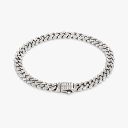 A silver-toned Cuban link chain bracelet with a rectangular clasp paved with small clear stones, photographed on a clean light gray background.