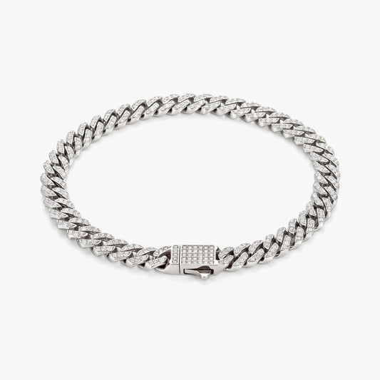 A silver-toned Cuban link chain bracelet with a rectangular clasp paved with small clear stones, photographed on a clean light gray background.