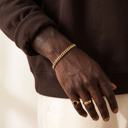 5mm gold curb chain bracelet on a man's hand with rings