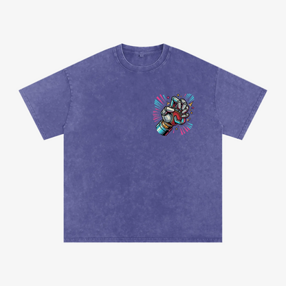 A short-sleeve crewneck t-shirt in a washed periwinkle blue color, featuring a colorful graphic of a clenched fist with a rainbow spectrum and red lightning accents on the left chest, displayed on a solid white background.