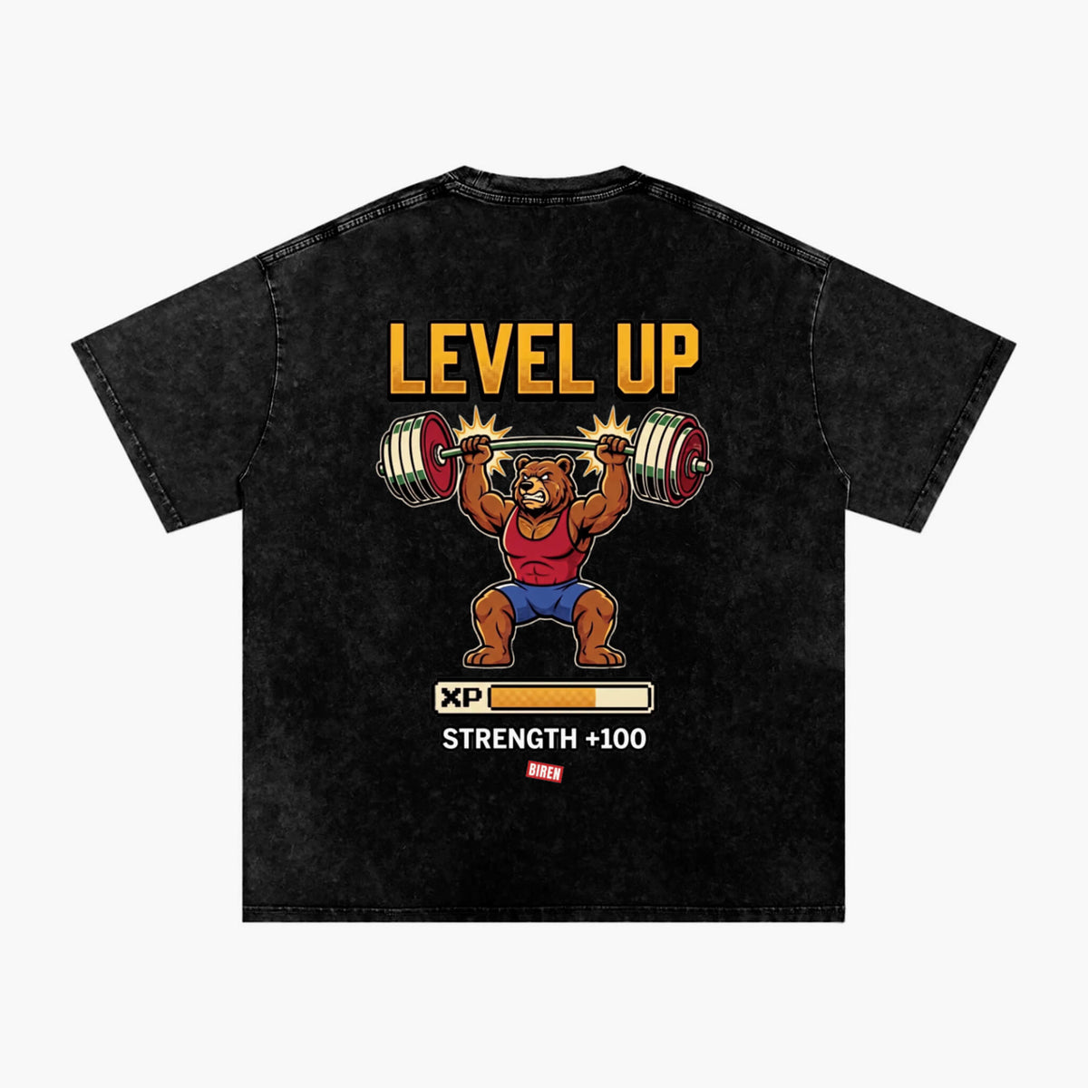 A black acid-wash graphic t-shirt featuring a cartoon bear lifting a barbell with the text 'LEVEL UP' and 'STRENGTH +100' on the back, displayed against a light gray background.