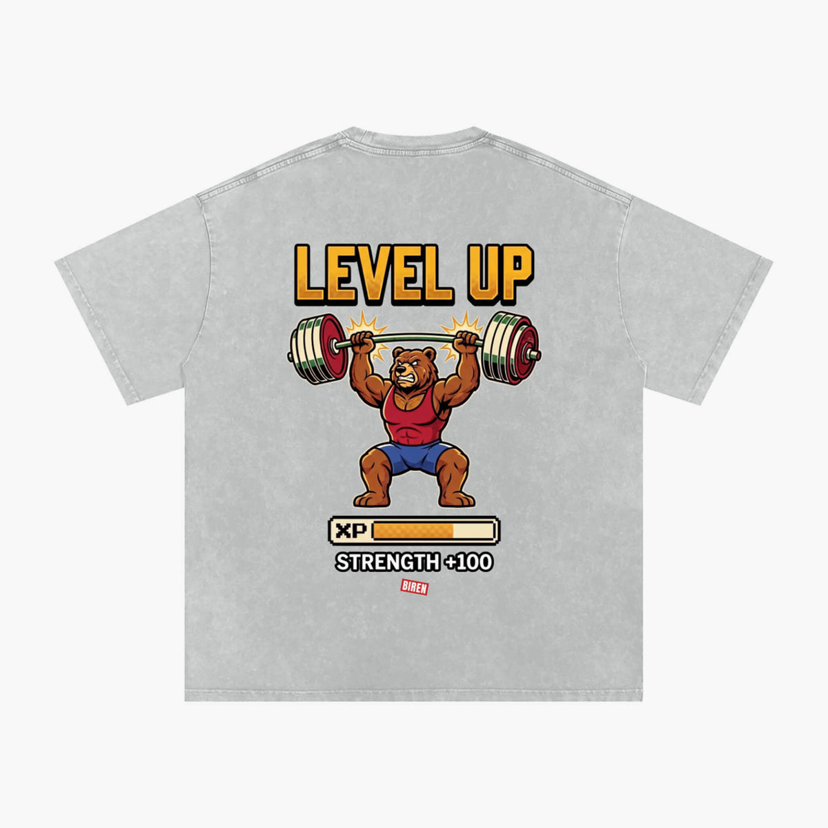 A light gray heathered t-shirt featuring a retro video game 'Level Up' graphic of a cartoon bear lifting a barbell, with 'LEVEL UP' in yellow text and a progress bar graphic below.